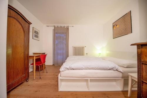 una camera con letto, scrivania e tavolo di Apartments Stina a Ortisei
