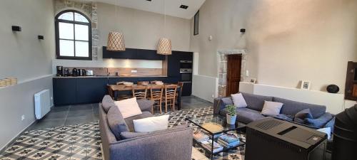 un salon avec deux canapés et une cuisine dans l'établissement Magnifique maison en coeur de Balazuc, proche plages ardèche, à Balazuc