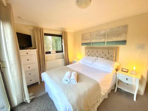 a bedroom with a bed with two slippers on it at 4 Bed House - Sleeps 9 - HotTub - Parking in Beattock