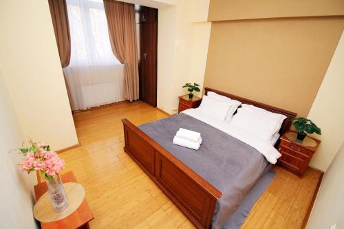 een slaapkamer met een groot bed en 2 handdoeken bij Стильная двушка в Золотом квадрате in Alma-Ata