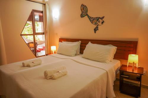 een slaapkamer met een bed met twee handdoeken erop bij Pousada Morada dos Ventos in Pipa