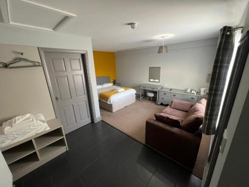 a bedroom with a bed and a couch in a room at The Black Horse Inn in Gainsborough