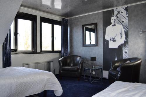 1 dormitorio con 2 sillas y una foto de un hombre en la pared en Kappelshamns Veranda och Fritidsboende, en Kappelshamn