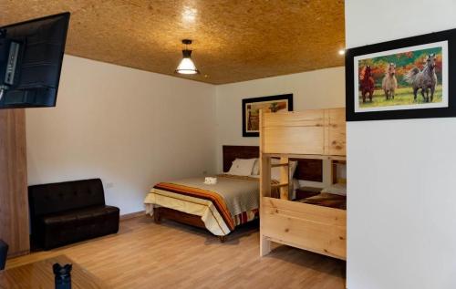 Habitación con 1 dormitorio con 1 cama y TV. en Tambo Lodge Canta, en Canta