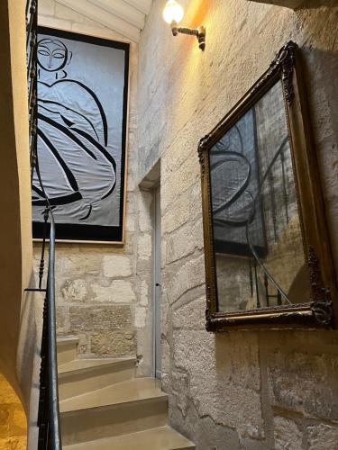 a mirror on the side of a wall with a staircase at Duplex Face au Palais in Avignon