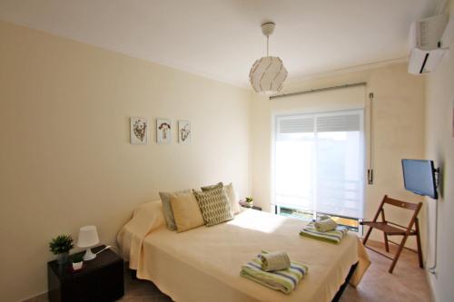 a bedroom with a bed and a window at Apartamento Oliveira in Santa Luzia