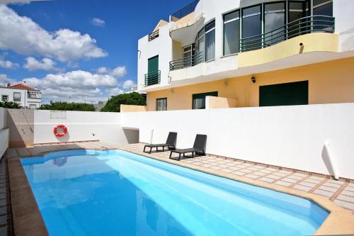 a swimming pool in front of a house at Apartamento Oliveira in Santa Luzia