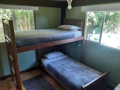 柴藤的住宿－Hostal La Minga，带两张双层床的客房,设有两扇窗户
