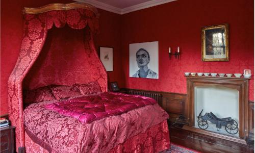 a bedroom with a bed with a red comforter at B&B Harlington Manor in Harlington