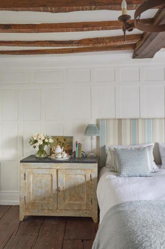 a bedroom with a bed and a table with flowers on it at B&B Harlington Manor in Harlington