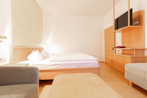 a small room with a bed and a couch at Gasthof zur Post in Sankt Kathrein am Hauenstein
