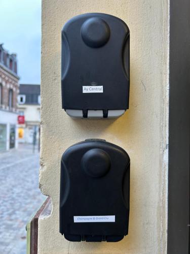two black speakers on the side of a wall at Champagne & Grand Cru in Ay