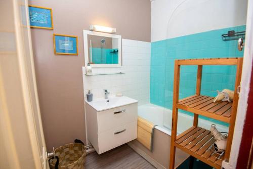 een badkamer met een wastafel en een bad bij LA BELLE PIERRE - Appartement de charme très calme en Cœur de Ville in Auxerre