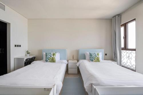 Ce lit se trouve dans un dortoir doté de murs blancs et d'une fenêtre. dans l'établissement Balqis Residense Palm Jumeirah,Pool, Beach, Top floor, Full sea view, Restaurants, à Dubaï