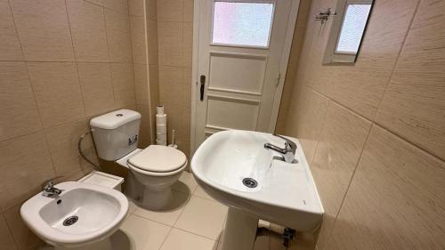 a white bathroom with a toilet and a sink at Coral Apartment in Lisbon