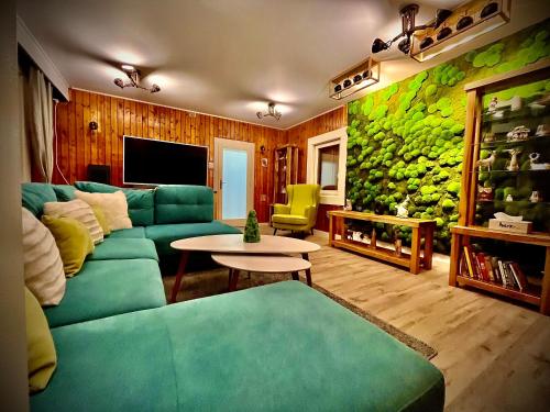 sala de estar con sofá verde y mesa en chata REINA en Pusté Pole