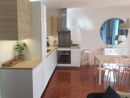 une cuisine avec des armoires blanches et une table dans l'établissement Coup de Cœur VIEUX PORT-République, à Marseille