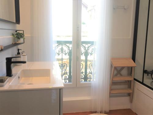 uma cozinha com um lavatório e uma janela em Coup de Cœur VIEUX PORT-République em Marselha