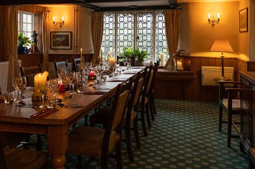 The Royal Oak Exmoor في Winsford: غرفة طعام مع طاولة وكراسي طويلة