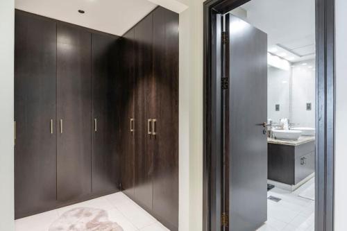 La salle de bains est pourvue d'armoires en bois sombre et d'un lavabo. dans l'établissement Balqis Residense Palm Jumeirah,Pool, Beach, Top floor, Full sea view, Restaurants, à Dubaï