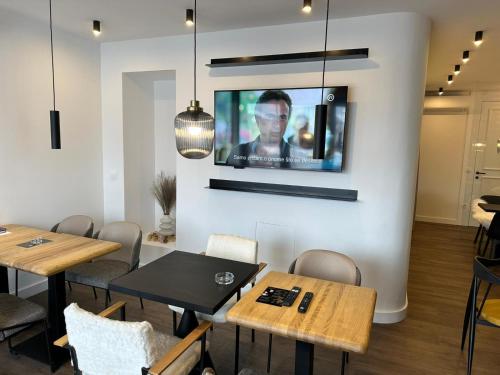 a dining room with tables and a tv on a wall at ConnectIN Apartments in Pale