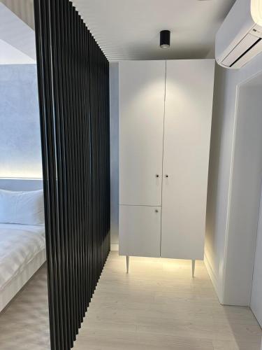 a bedroom with a white bed and a black wall at ConnectIN Apartments in Pale