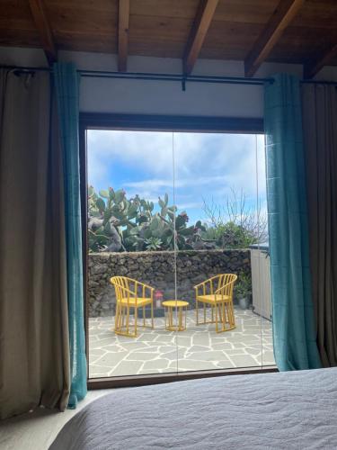 a bedroom with a view of a patio with a table and chairs at La Cuadra de Pascuala in Tajace de Abajo