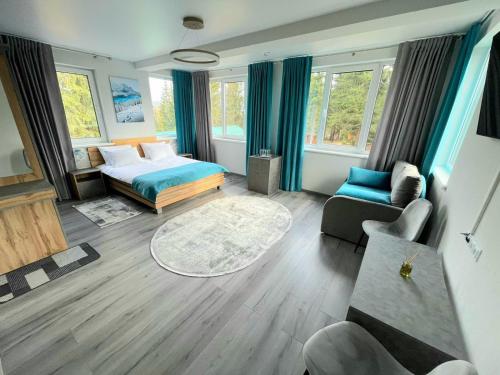 uma sala de estar com uma cama e um sofá em Отель MONBLAN em Yablunytsya