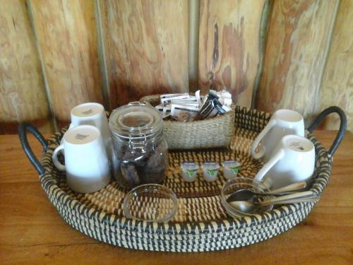 a basket with dishes and utensils on a table at Greenfire Drakensberg Lodge in Bonjaneni