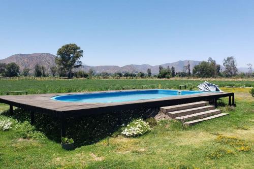 a swimming pool in a field with mountains in the background at Casa de Campo Viña el Campesino con Tinaja Caliente y Piscina in Melipilla