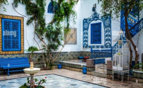 a building with blue and white walls and a bench at Dar zmen in Tunis