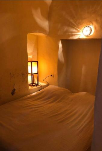 a bedroom with a bed with a window and a clock at Dar zmen in Tunis