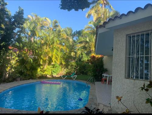 a swimming pool in front of a house at CASA BETTY COSTAMBAR in San Felipe de Puerto Plata