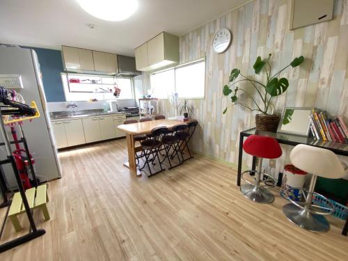 eine Küche mit einem Tisch und Stühlen sowie einem Kühlschrank in der Unterkunft 浜町小院 Guest House in Takamatsu