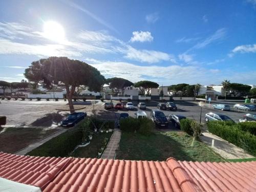 een uitzicht op een parkeerplaats met geparkeerde auto's bij Apartamento moderno frente a la playa San Miguel in El Rompido