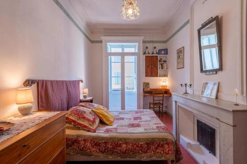 une chambre avec un lit et une cheminée dans l'établissement Le Pontias, à Nyons