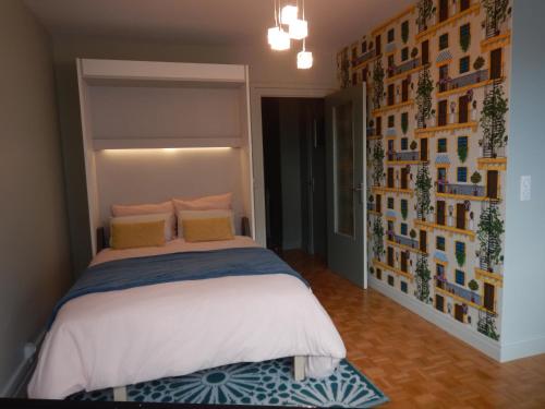 1 dormitorio con 1 cama y una pared de cuadros en Studio Quartier Château - Wifi - Garage individuel à clé - Electroménager complet, en Pau