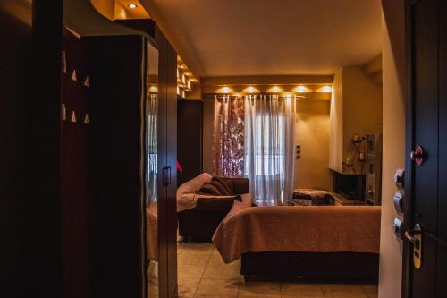 a bedroom with a bed and a couch and a window at Bojana' s luxury house in Larisa