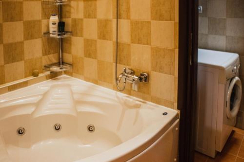 a bath tub in a bathroom with a washing machine at Bojana' s luxury house in Larisa