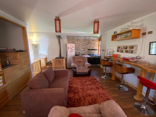 a living room with a couch and a bar at La Casa de Carlitos in San José de Maipo