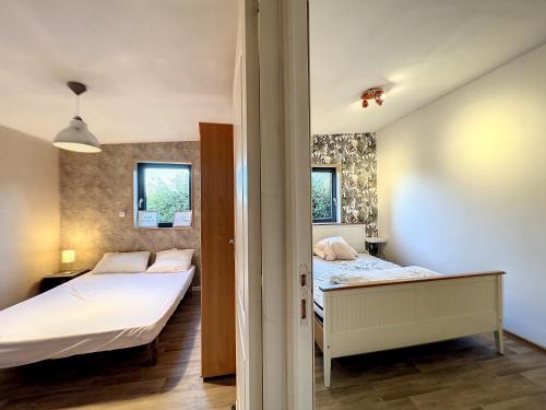 - 2 lits dans une chambre avec 2 fenêtres dans l'établissement Appartement bucolique proche Rennes et Brocéliande, à Saint-Thurial