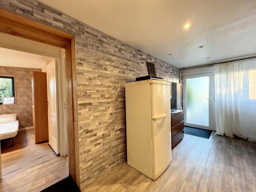 Cette chambre dispose d'un réfrigérateur et d'un mur en briques. dans l'établissement Appartement bucolique proche Rennes et Brocéliande, à Saint-Thurial