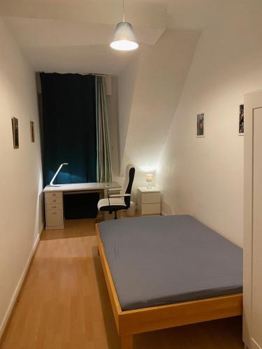 Habitación pequeña con cama y escritorio. en Nice Private Room in Shared Apartment - 2er WG, en Wiesbaden