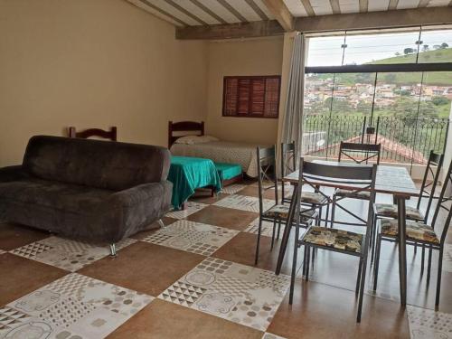 salon z kanapą, stołem i krzesłami w obiekcie Amplo Loft integrado com vista para montanhas! w mieście Itanhandu