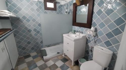 La salle de bains est pourvue de toilettes, d'un lavabo et d'un miroir. dans l'établissement La Cuadra de Pascuala, à Tajace de Abajo