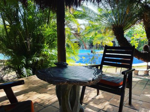 a chair sitting on a patio with a view of a pool at Pousada Morada dos Ventos in Pipa