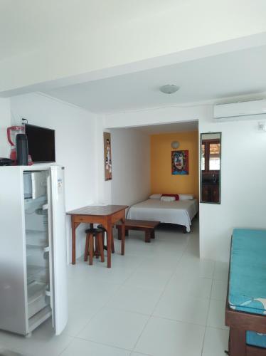 a room with a bed and a table and a bed sidx sidx sidx at Pousada Residence Vila das Flores in Morro de São Paulo