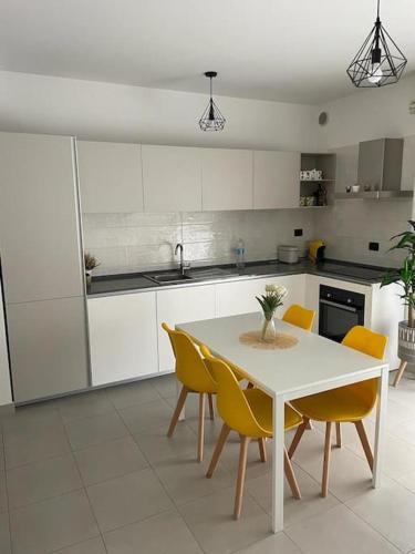 una cucina con tavolo bianco e sedie gialle di Boutique Apartment a Pescara