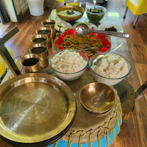 a table with many bowls of food on it at Homestay by the Tea Garden Dibrugarh in Dibrugarh