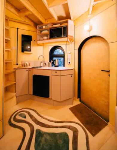 Cette chambre comprend une cuisine avec un évier et une porte. dans l'établissement Le pigeonnier - TinyHouse en plein centre de Liège, à Liège